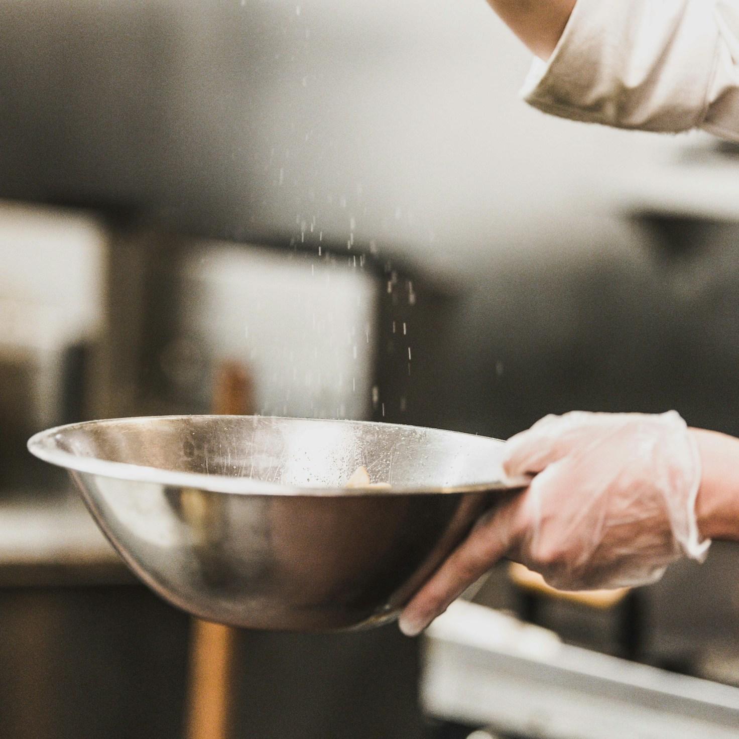 Community members collaborating in a contemporary kitchen, sharing recipes and cooking techniques